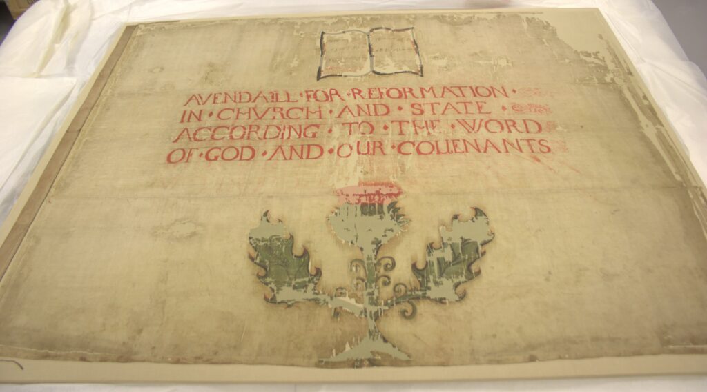 Photograph of the banner from the bottom at an oblique angle, on a white background.