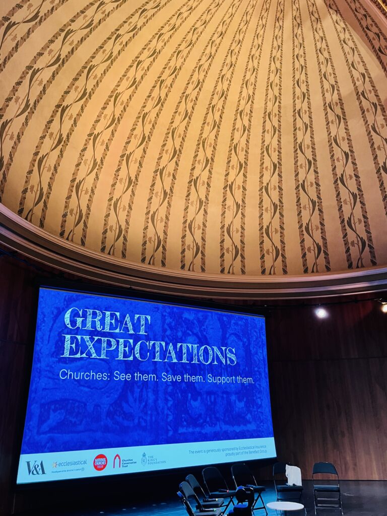 Photo from inside the V&A with the stage and screen with conference branding