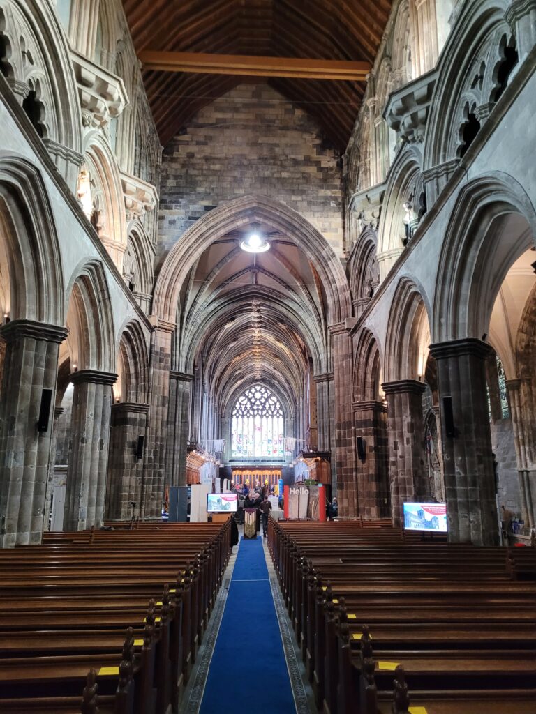 Colour photograph of interior of church from the aisle, with carved stone walls